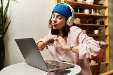 Genç bir kadın, yaratıcılığını ifade ederek, modern bir kafede uzaktan çalışmakla mutlu bir şekilde meşgul..