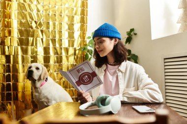 Labradoru modern bir kafe ortamında dinlenirken genç bir kadın menü okuyor..