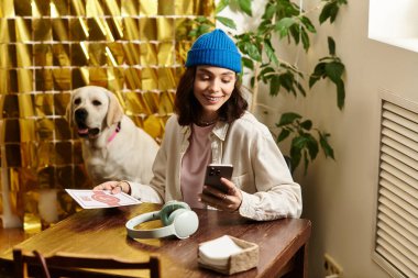 Genç bir kadın labradoruyla rahatlıyor, hoş bir kafede hayat dolu bir atmosferin tadını çıkarıyor..
