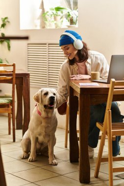 Genç bir kadın, labradoruyla rahat ve modern bir kafe ortamında kaliteli vakit geçirmekten hoşlanıyor..