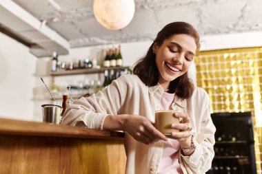 Genç bir kadın şık bir kafe ortamında dinlenirken sıcak içkisinin tadını çıkarıyor..