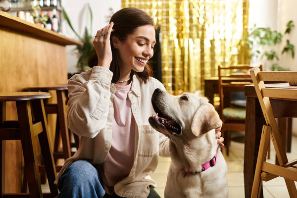 A young woman shares a delightful moment with her labrador at a vibrant pet friendly cafe.