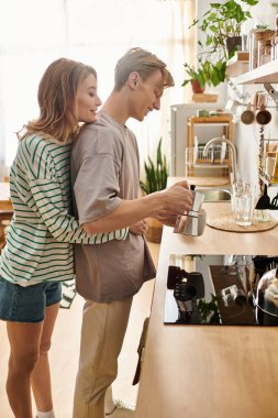 Genç bir çift sıcak, davetkar mutfaklarında kahve hazırlarken birbirlerine eşlik etmekten zevk alır..