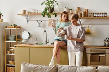 Genç bir çift sıcak bir ev atmosferiyle çevrili kahve demlerken neşeli bir anın tadını çıkarıyor..