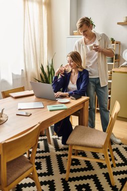 Şık bir çift evde rahatlar, içki yudumlarken ve birlikte çalışırken hafif bir anı paylaşırlar..
