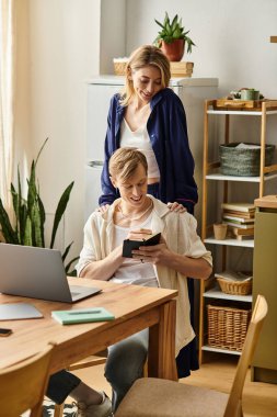 Sevgili çift gülüyor ve şık evlerinde bir aletle kaliteli vakit geçirmekten zevk alıyor..