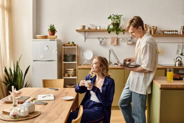 Güneşli bir günde eve davet edilirken sıcak bir içkiyi paylaşan genç bir çift..