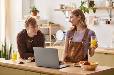 Şık mutfaklarında, genç bir çift birlikte kahkaha, kahvaltı ve bir neşe anlarını paylaşıyor..