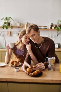 Sevgi dolu bir çift, davetkar mutfaklarında kruvasan ve kahve ile keyifli bir kahvaltı yapar..