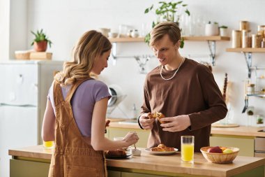 İki genç aşık, rahat ve modaya uygun mutfaklarında keyifli bir kahvaltı anı paylaşıyorlar..
