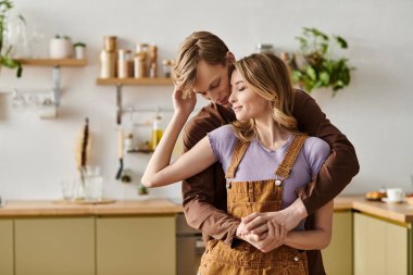 Sıcak bir mutfakta, genç bir çift sıcak dekorlarla çevrili sevgi dolu bakışlarını paylaşıyor..