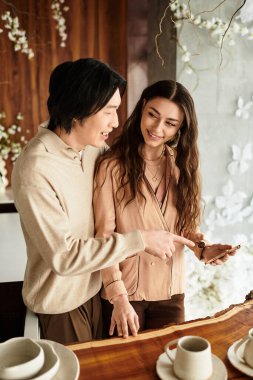 Güzel dekorasyon ve sıcaklıkla çevrili bir çift heyecanlı bir şekilde düğün planlarını tartışıyor..