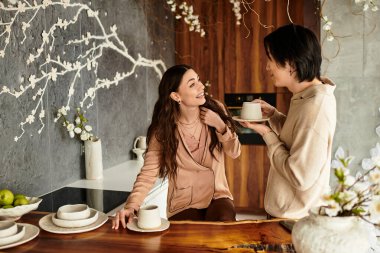 İki eş, düğün hazırlıkları ve canlı mutfak dekorunun ortasında keyifli bir anın tadını çıkarıyor..