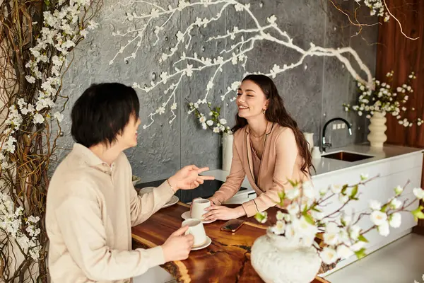 Neşeli bir çift, şık bir mutfakta kahve içerken düğünleri hakkında heyecanlı bir şekilde sohbet eder..