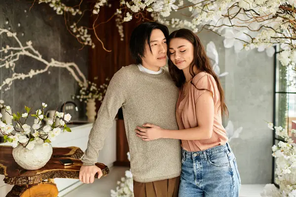 Neşeli bir çift, güzel çiçeklerin arasında düğünlerine hazırlanırken kucaklaşır..