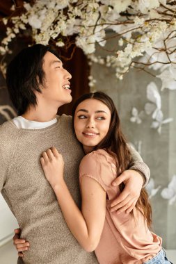 İki insan, güzel çiçeklerin arasında düğün hazırlıkları yaparken aynı hassas anı paylaşır..