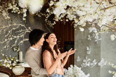 Sevgi dolu bir çift, düğünlerine hazırlanırken değerli anların tadını çıkarır. Çiçeklerle çevrili..