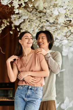 Çiçeklerle çevrili, düğünlerine hazırlanan bir çift gülümseme..