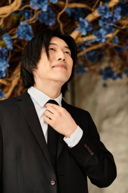 Damat gururla durur, kravatını düzeltir ve gülümser, çiçeklerin arasında özel gününe hazırdır..