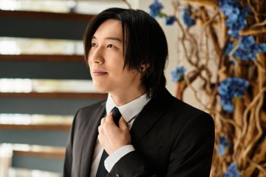 Genç damat kravatını düzeltir, özel düğün günü için neşe ve heyecan saçar..