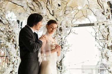 Neşeli bir çift birbirlerine aşklarını sergilerken etrafları çiçeklerle çevrili..