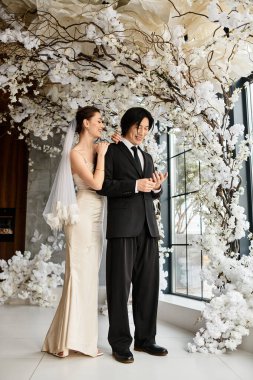 Genç bir çift, aşklarını kutlayan güzel beyaz çiçeklerin arasında hassas anları paylaşıyor..