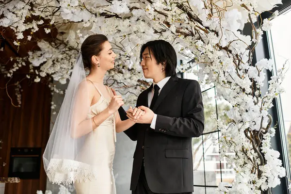 Bir çift, zarif beyaz çiçekler arasındaki birlikteliklerini neşeyle kutluyor..