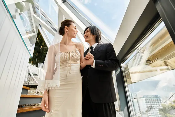 Neşeli bir çift, düğünlerini güzelce tasarlanmış bir ortamda kutlarken kucaklaşır..