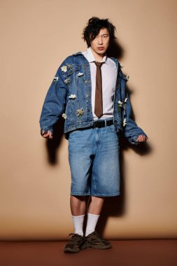 Asyalı bir adam yaratıcı stüdyo içinde şık bir bahar kıyafetine güvenir..