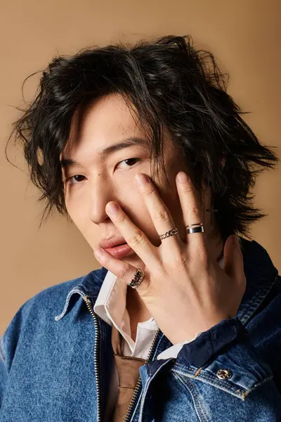 Asyalı bir adam modaya uygun bahar kıyafetleri, eşsiz aksesuarlar ve uzman tasarımları sergiliyor..