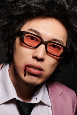 Stüdyoda bahar modasında yüzü kanlı şık Asyalı bir adam.