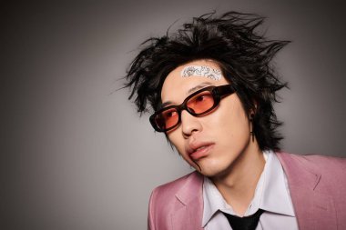 Yüzünde kan olan Asyalı bir adam şık giyinmeye özgüven yayar. Stüdyoda bahar modasını somutlaştırır..