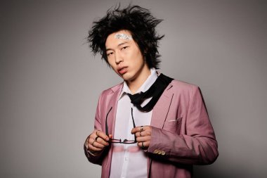 Yüzünde kan olan Asyalı bir adam bahar zamanı yaratıcı bir stüdyo ortamında eşsiz bir moda sergiliyor..