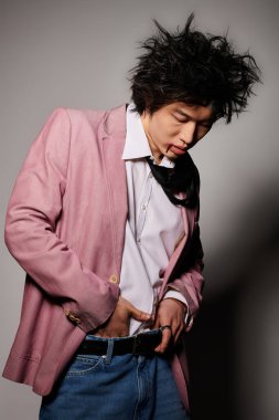 Yüzünde kan lekesi olan Asyalı bir adam bahar sezonunda stüdyoda güven içinde poz veriyor..