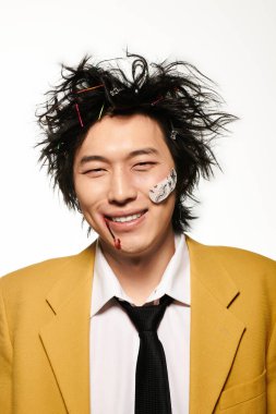 Yüzünde kan olan Asyalı bir adam bahar aylarında modern bir stüdyoda eşsiz bir stil sergiliyor..