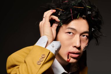 Yüzünde kan olan Asyalı bir adam moda bahar modasını sergiliyor ve stüdyo arkaplanına güven yayıyor..