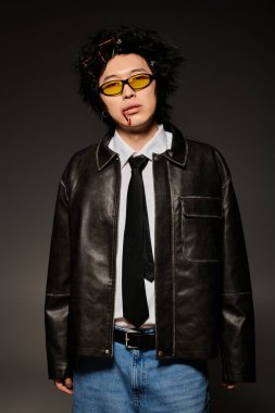 Yüzünde kan olan Asyalı bir adam modaya uygun bahar kıyafetleri içinde modern bir stüdyo ışıklandırmasına güveniyor..