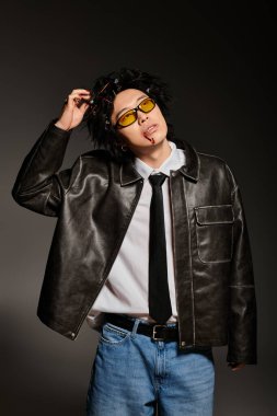 Dövüşten sonra yüzü kan içinde olan Asyalı bir adam kendine güvenen moda anlayışını bahar havası için mükemmel bir kıyafetle sergiliyor..