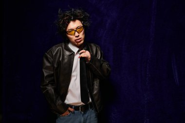 Yüzünde kan olan Asyalı bir adam yaratıcı stüdyo ortamında cesur bahar moda demecini sunar..