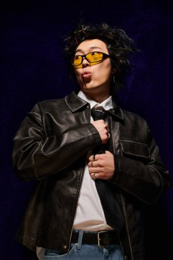 Modern bahar kıyafeti giymiş yüzü kanlı Asyalı bir adam yaratıcı bir stüdyo ortamında güven içinde poz veriyor..