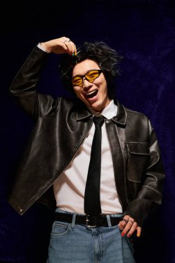 Asyalı bir adam modaya uygun bir bahar modası sergiliyor. Stüdyoda kendine güveni ve cazibesi var..