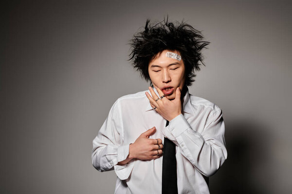 An Asian man in stylish clothes toughing face after fight