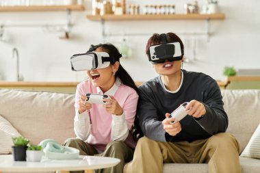 Neşeli genç çift oyun oynarken VR kulaklık takıyor, neşeli dünyalarına dalmış..