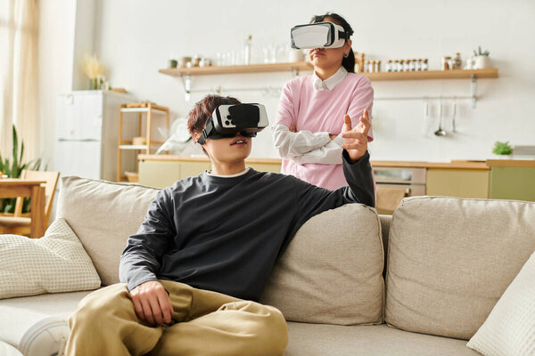 A young asian couple engages with virtual reality headsets, sharing an immersive experience at home.