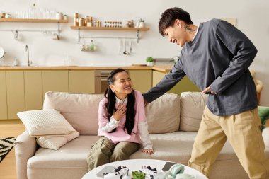 Genç Asyalı bir çift rahat bir kanepede dinlenirken birbirlerine eşlik etmekten zevk alır.