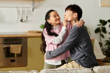 Genç Asyalı bir çift, neşe ve kahkaha dolu evde neşeli bir anın tadını çıkarıyor..