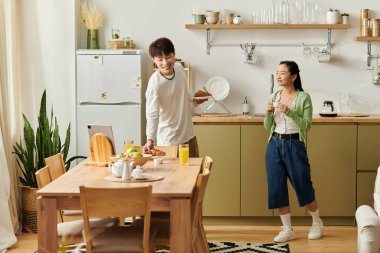 Genç bir çift, davetkar mutfaklarında kahvaltıdan zevk alarak neşeli bir atmosfer yaratıyor..