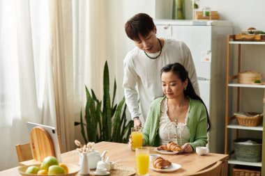 Genç bir çift, sevgi ve neşe dolu bir şekilde evde kahvaltı yapıyor..