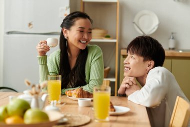 Gülücükler ve kahkahalarla, genç bir çift evde keyifli bir kahvaltı yapar..