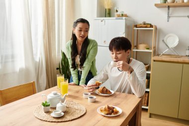 Genç bir çift keyifli bir kahvaltı yapar, evlerinde hamur işlerinin ve içkilerin tadını çıkarırlar..